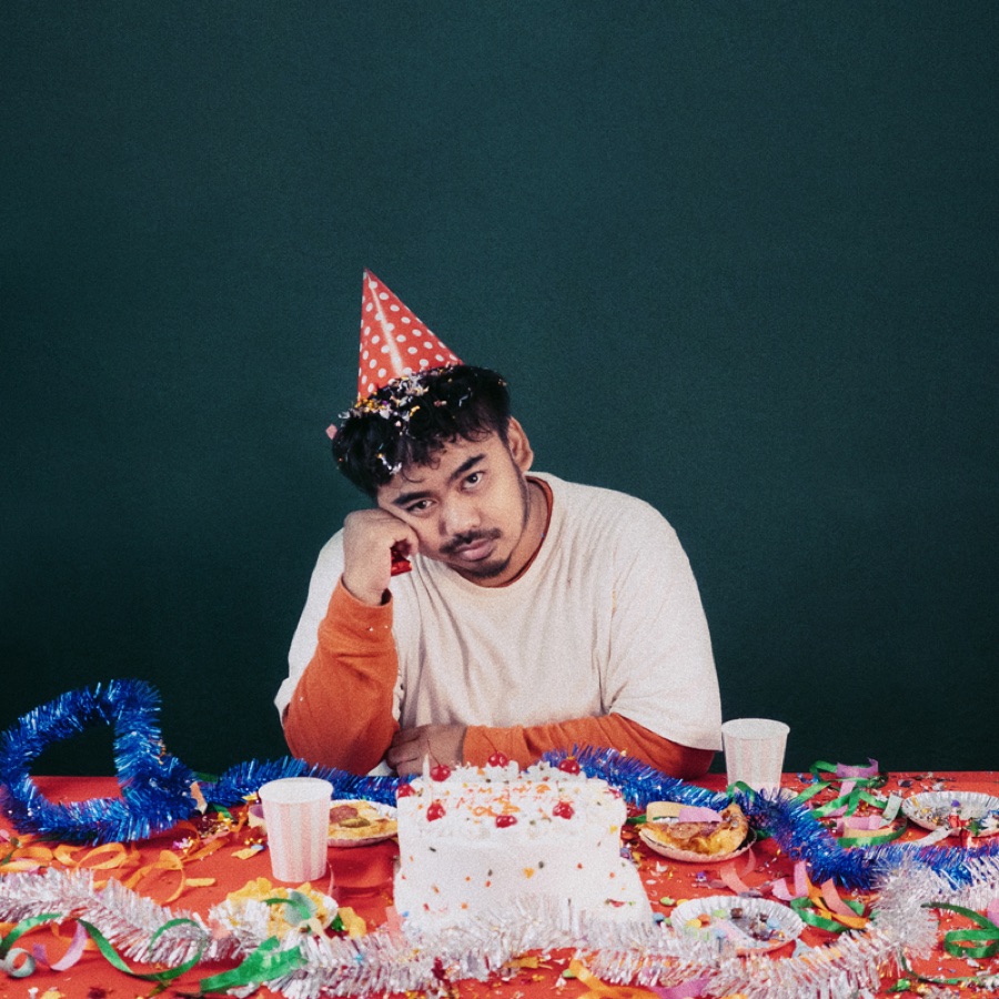 Reza Ilham wearing a party hat at a birthday table